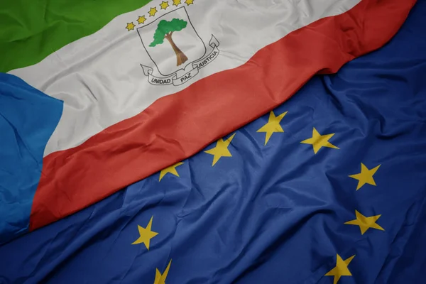 Agitant drapeau coloré de l'union européenne et drapeau de la Guinée équatoriale . — Photo
