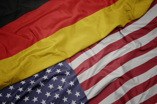 Acenando bandeira colorida dos estados unidos da América e bandeira nacional da alemanha. macro — Fotografia de Stock