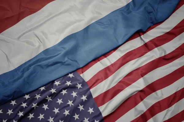 Mávat barevnou vlajku Spojených států amerických a státní vlajky Lucemburska. Makro — Stock fotografie