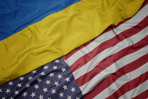 Acenando bandeira colorida dos estados unidos da América e bandeira nacional da Ucrânia. macro — Fotografia de Stock