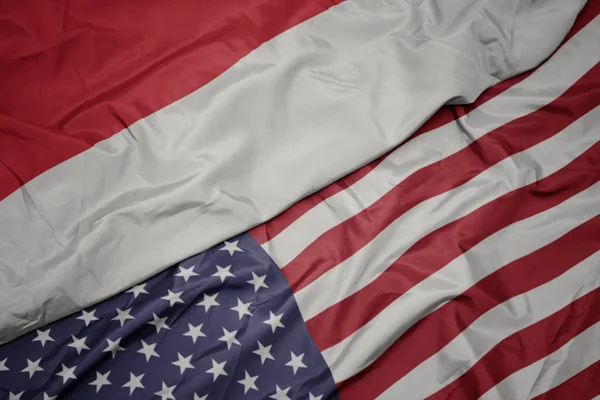 Acenando bandeira colorida dos estados unidos da américa e bandeira nacional da indonésia . — Fotografia de Stock