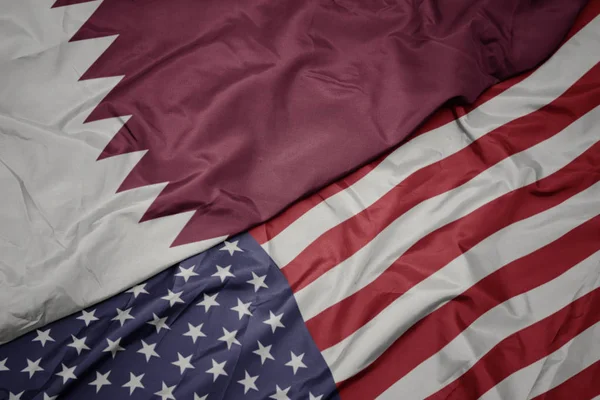 Waving colorful flag of united states of america and national flag of qatar. — Stock Photo, Image