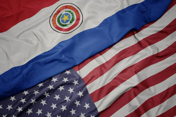 Ondeando colorida bandera de estados unidos de América y bandera nacional de paraguay . — Foto de Stock