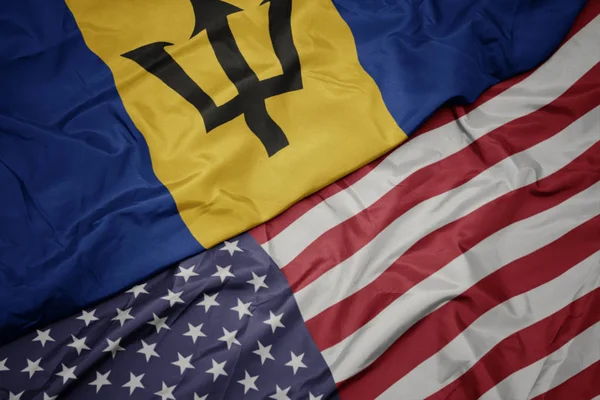 Waving colorful flag of united states of america and national flag of barbados. — Stock Photo, Image