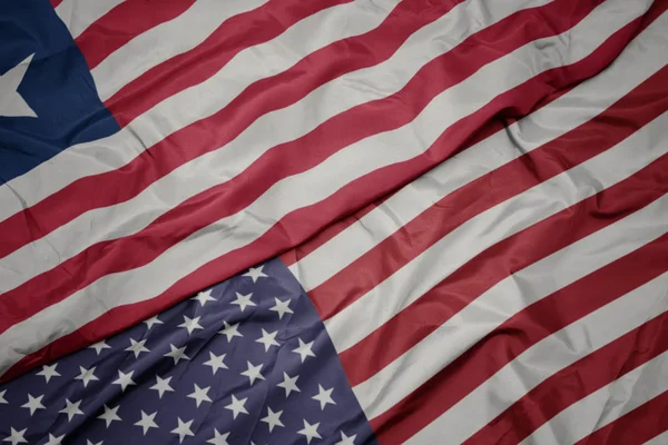 Waving colorful flag of united states of america and national flag of liberia. — Stock Photo, Image