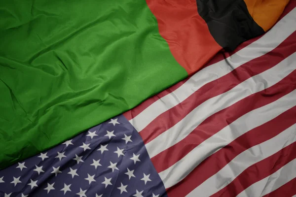 Sventolando bandiera colorata degli Stati Uniti d'America e bandiera nazionale della zambia . — Foto Stock