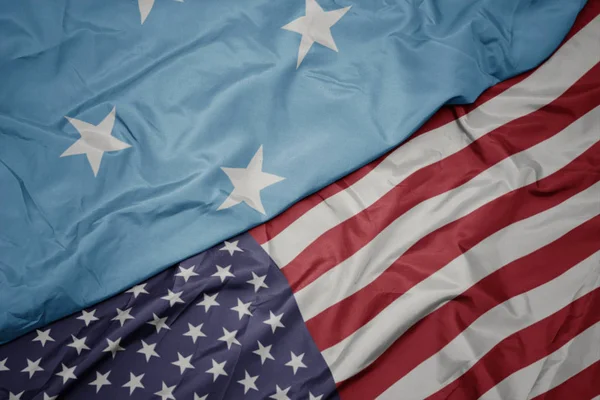 Κυματιστό πολύχρωμο σημαία των Ηνωμένων Πολιτειών της Αμερικής και της εθνικής σημαίας των ομόσπονδων κρατών της Μικρονησίας. — Φωτογραφία Αρχείου