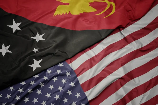 Agitant le drapeau coloré des États-Unis d'Amérique et le drapeau national de Papouasie-Nouvelle-Guinée . — Photo
