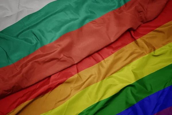 Sventolando colorata bandiera gay arcobaleno e bandiera nazionale della Bulgaria . — Foto Stock