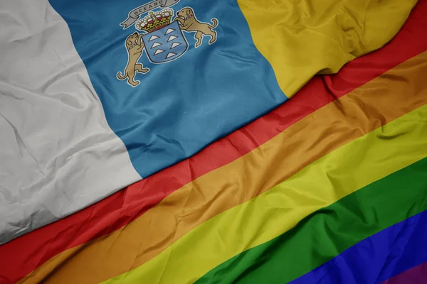 カラフルなゲイの虹の旗とカナリア諸島の国旗を振る. — ストック写真