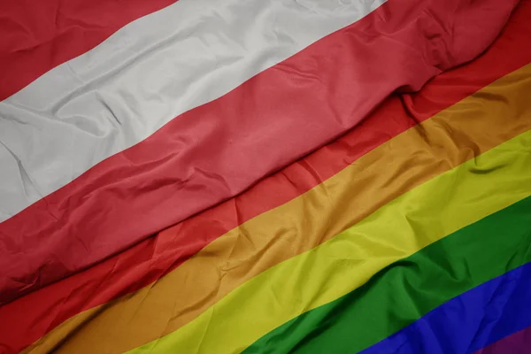 Waving colorful gay rainbow flag and national flag of austria. — Stock Photo, Image