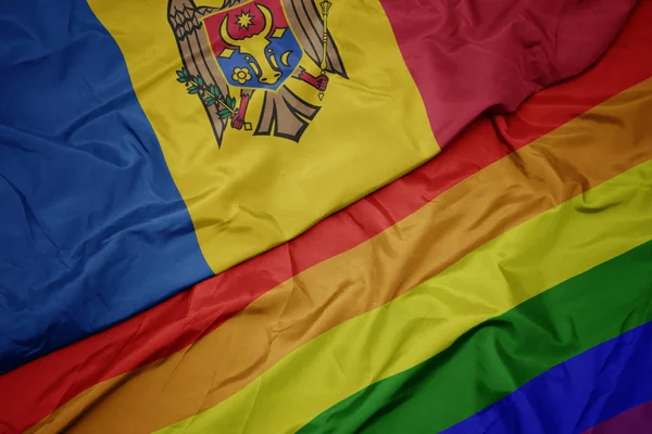 Waving colorful gay rainbow flag and national flag of moldova. — Stock Photo, Image