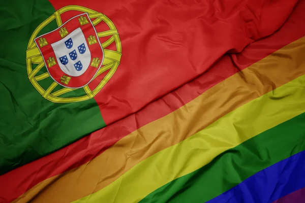 Ondeando colorido arco iris gay bandera y bandera nacional de portugal . —  Fotos de Stock