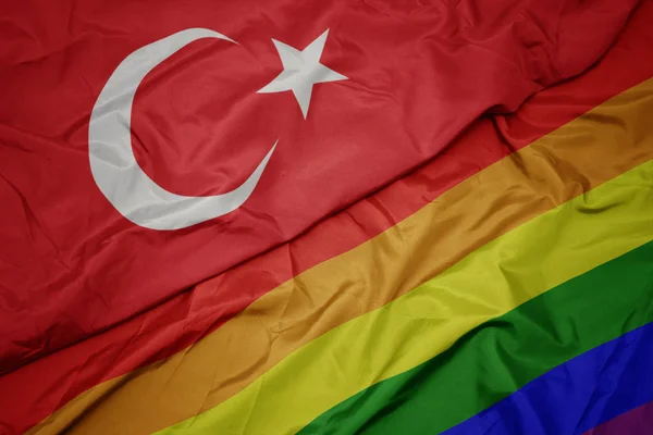 挥舞着五颜六色的同性恋彩虹旗和火鸡国旗. — 图库照片