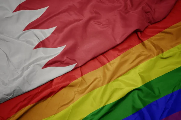 Schwenken bunte schwule Regenbogenfahne und Nationalflagge Bahrain. — Stockfoto