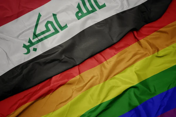 Sventolando colorata bandiera arcobaleno gay e bandiera nazionale dell'Iraq . — Foto Stock