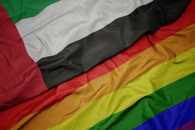 renkli gay gökkuşağı bayrağı ve birleşik arap emirlikleri ulusal bayrağı sallayarak.