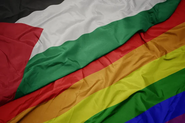 Waving colorful gay rainbow flag and national flag of palestine. — Stock Photo, Image