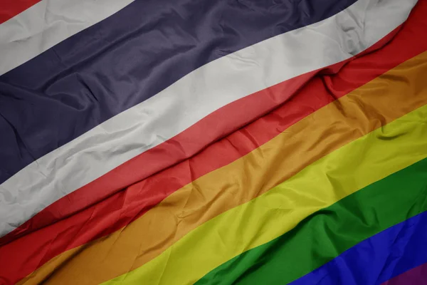 Waving colorful gay rainbow flag and national flag of thailand. — Stock Photo, Image