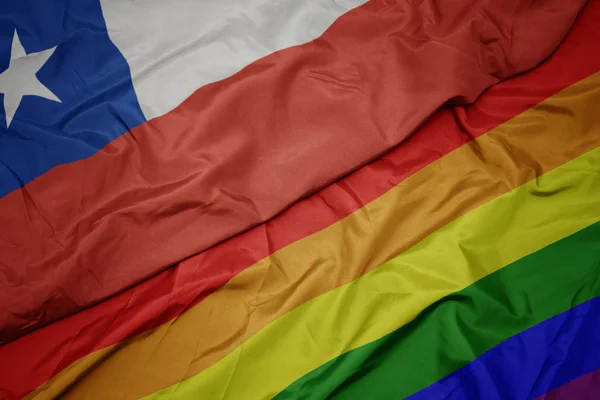 Zwaaiende kleurrijke Gay regenboog vlag en nationale vlag van Chili. — Stockfoto