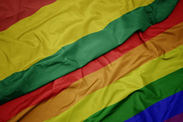 Махаючи барвистий гей веселка прапор і національний прапор Болівії . — стокове фото