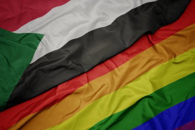 renkli gay gökkuşağı bayrağı ve sudan ulusal bayrak sallayarak.