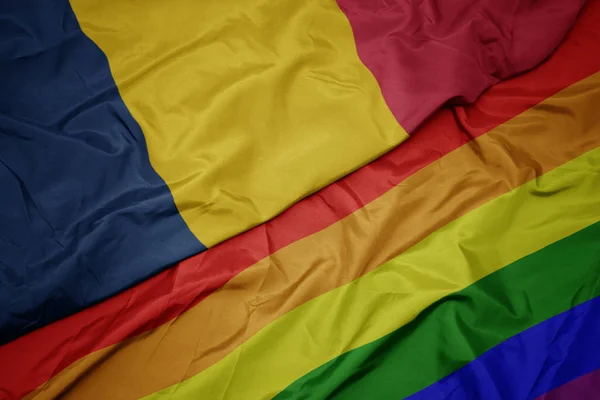 Waving colorful gay rainbow flag and national flag of chad. — Stock Photo, Image