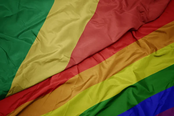 Ondeando colorida bandera arco iris gay y bandera nacional de la república del congo . — Foto de Stock