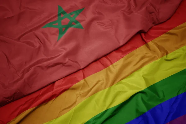 Waving colorful gay rainbow flag and national flag of morocco. — Stock Photo, Image