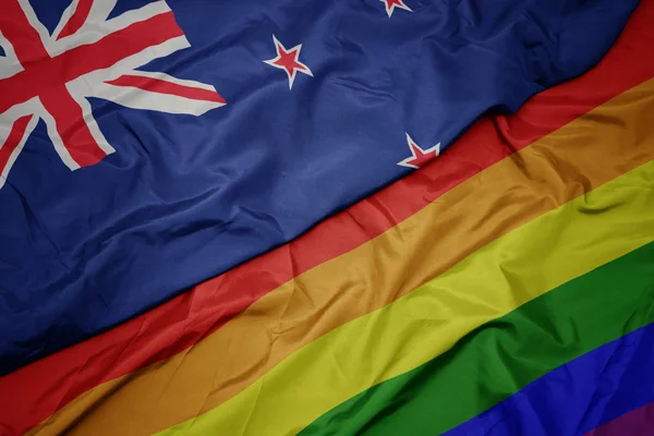 Agitant drapeau arc-en-ciel gay coloré et drapeau national de la Nouvelle-Zélande . — Photo
