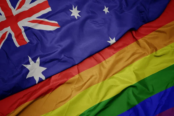 Waving colorful gay rainbow flag and national flag ofaustralia . — Stock Photo, Image