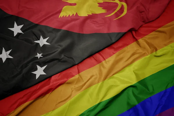 Integetett színes homoszexuális Szivárvány zászló és a nemzeti zászló Pápua Új-Guinea. — Stock Fotó