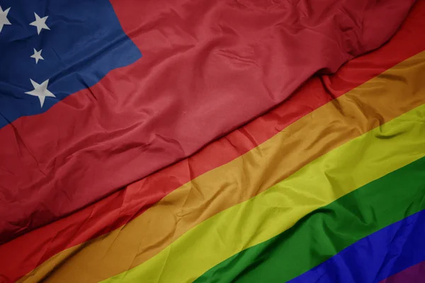 Waving colorful gay rainbow flag and national flag of Samoa. — Stock Photo, Image