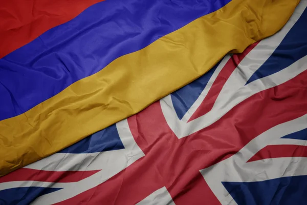 Schwenken bunte Flagge von Großbritannien und Nationalflagge von Armenien. — Stockfoto