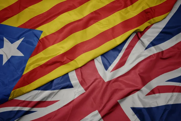 Sventolando bandiera colorata di grande britannico e bandiera nazionale della Catalogna . — Foto Stock