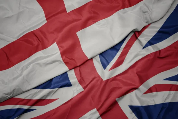 Acenando bandeira colorida de grande britânico e bandeira nacional da inglaterra . — Fotografia de Stock