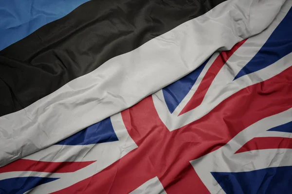 Ondeando colorida bandera de Gran Bretaña y bandera nacional de Estonia . —  Fotos de Stock