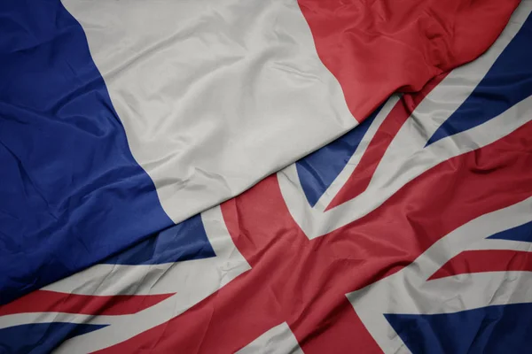 Acenando bandeira colorida de grande britânico e bandeira nacional da frança . — Fotografia de Stock