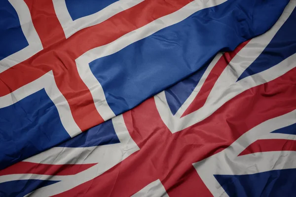 Waving colorful flag of great britain and national flag of iceland. — Stock Photo, Image