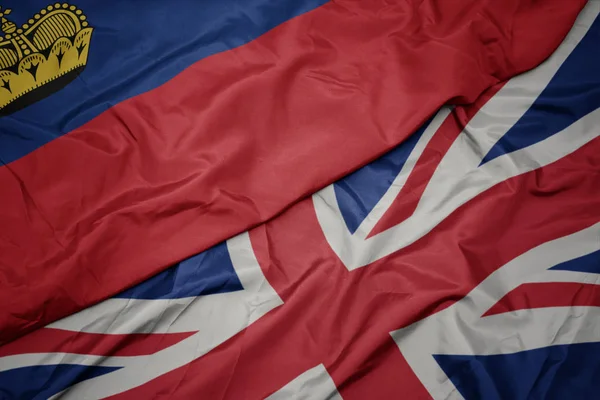 Acenando bandeira colorida de grande britânico e bandeira nacional de liechtenstein . — Fotografia de Stock