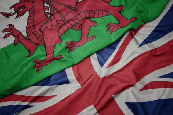 Waving colorful flag of great britain and national flag of wales. — Stock Photo, Image