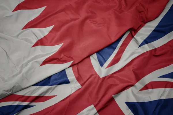 Acenando bandeira colorida de grande britânico e bandeira nacional do Bahrein . — Fotografia de Stock