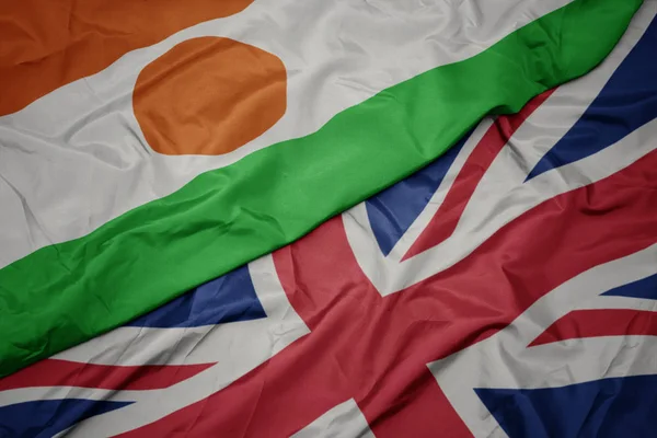 Waving colorful flag of great britain and national flag of niger. — Stock Photo, Image