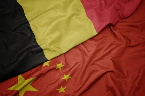 挥舞着五颜六色的中国国旗和比利时国旗. — 图库照片