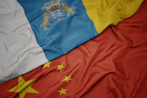 Размахивая красочным флагом Китая и национальным флагом канарейных островов . — стоковое фото