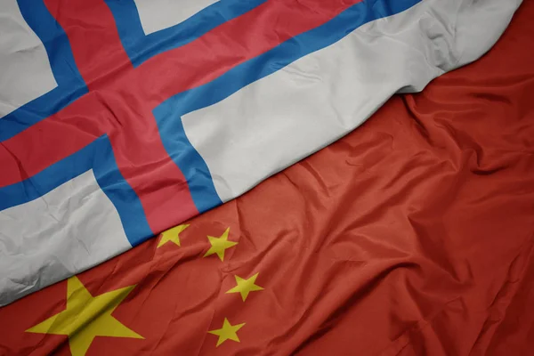 Sventolando bandiera colorata della Cina e bandiera nazionale delle isole Faroe . — Foto Stock