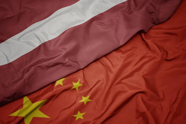 Waving colorful flag of china and national flag of latvia. — Stock Photo, Image