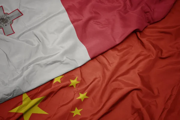 中国のカラフルな旗とマルタの国旗を振る. — ストック写真
