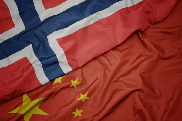 Agitant le drapeau coloré de la Chine et le drapeau national de norway . — Photo