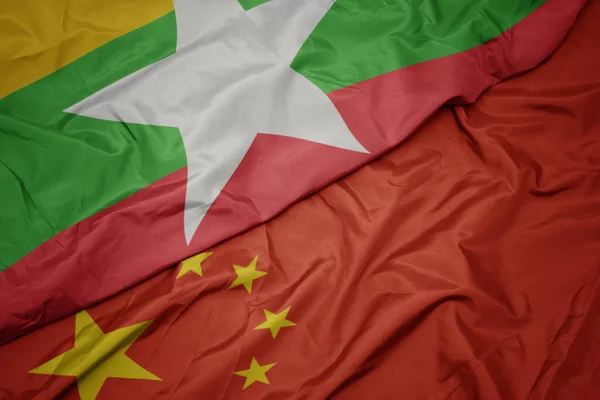 Ondeando colorida bandera de China y bandera nacional de myanmar . — Foto de Stock